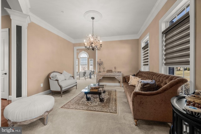 carpeted living room with a notable chandelier, crown molding, baseboards, and decorative columns