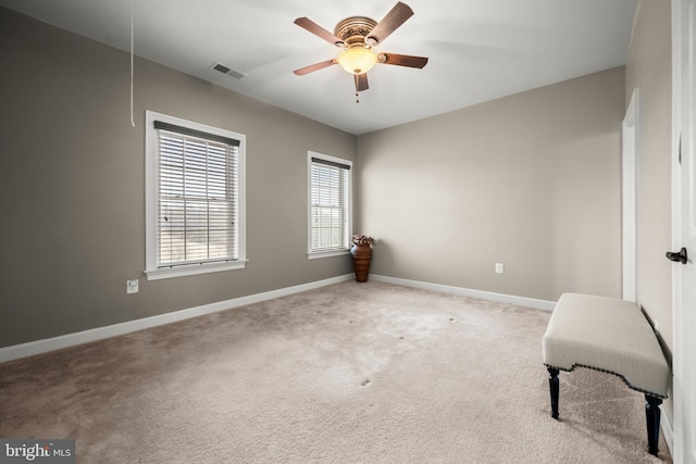 spare room featuring visible vents, ceiling fan, baseboards, attic access, and carpet floors