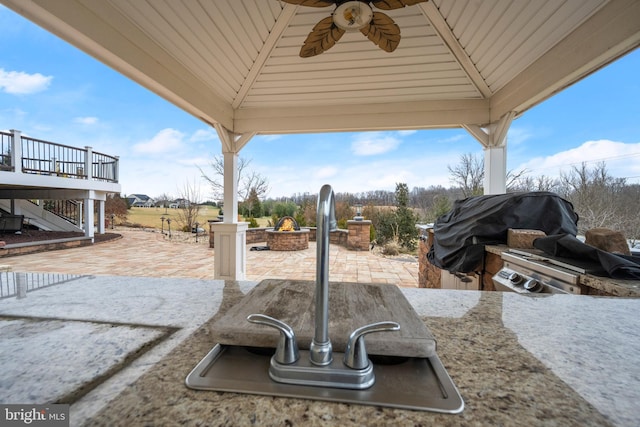 details with an outdoor fire pit, stairs, ceiling fan, and a sink