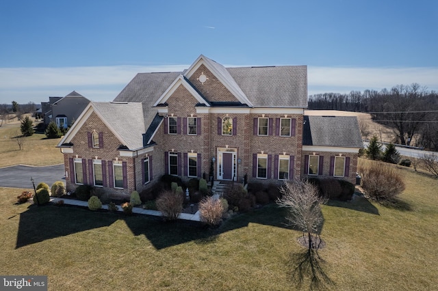 view of front of home with brick siding and a front lawn