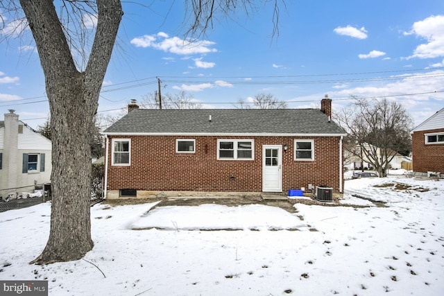 snow covered house with central AC