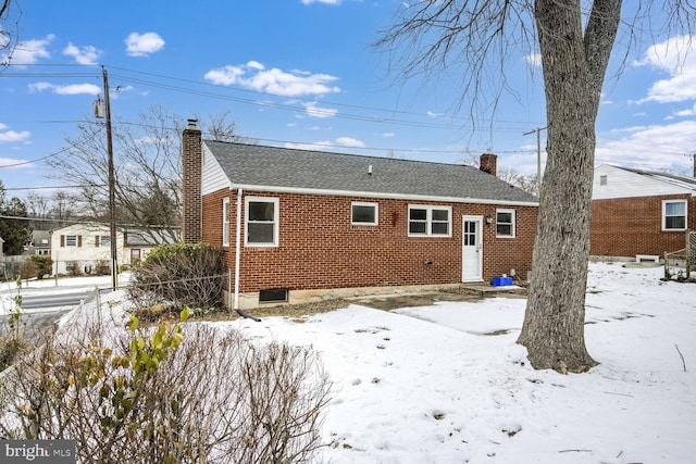 view of snow covered rear of property