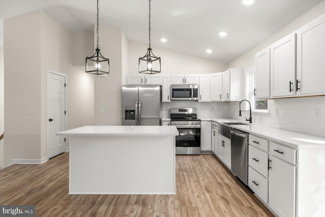 kitchen with appliances with stainless steel finishes, a center island, white cabinetry, and pendant lighting