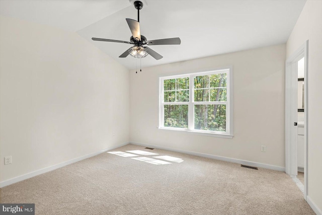 empty room featuring ceiling fan, light carpet, and vaulted ceiling