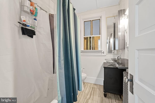 bathroom with walk in shower, vanity, and toilet