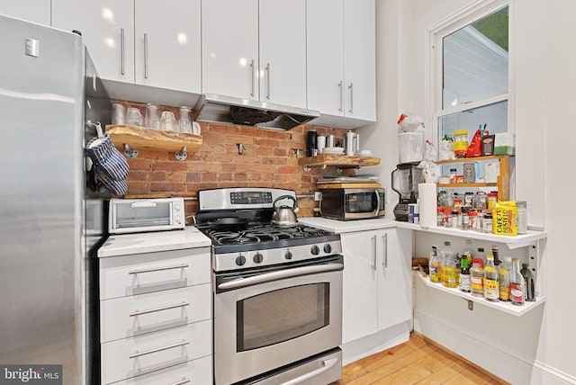 kitchen with tasteful backsplash, ventilation hood, stainless steel appliances, light hardwood / wood-style flooring, and white cabinetry