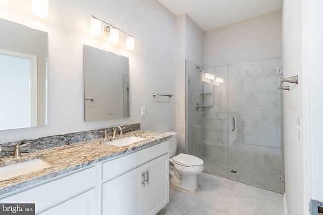 bathroom featuring tile patterned floors, vanity, toilet, and a shower with shower door