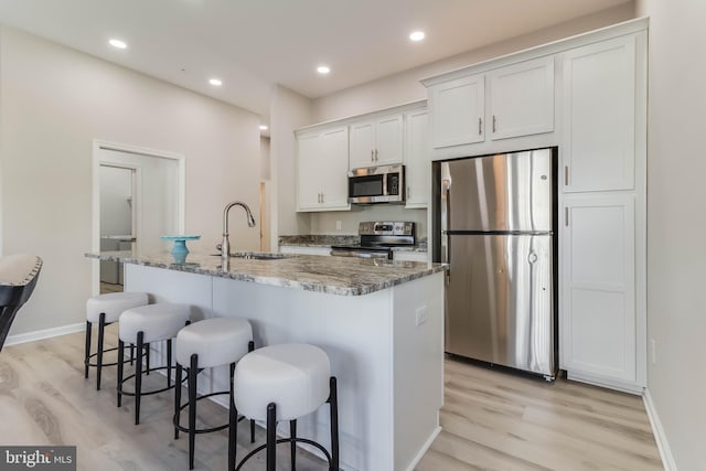 kitchen with sink, white cabinets, a center island with sink, and appliances with stainless steel finishes