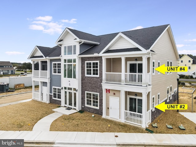 view of front of property featuring a balcony and central AC unit