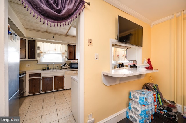 kitchen featuring dishwasher, light tile patterned flooring, and dark brown cabinetry