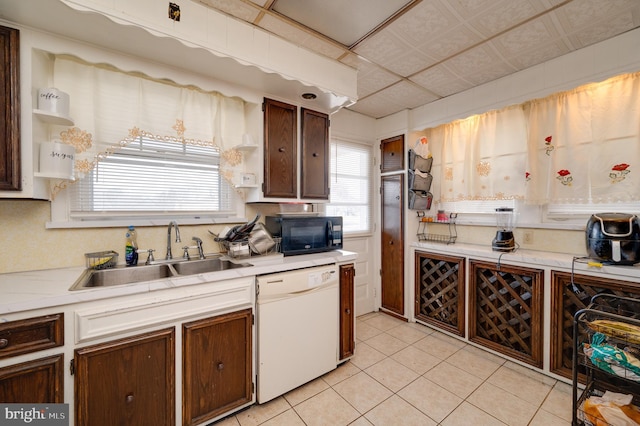 kitchen featuring dishwasher, light tile patterned flooring, and sink