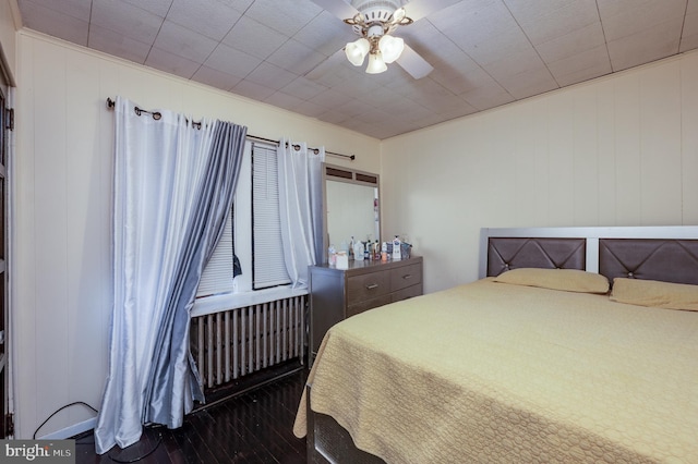 bedroom featuring hardwood / wood-style floors, ceiling fan, and radiator