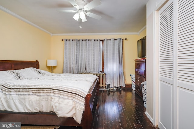 bedroom with dark hardwood / wood-style flooring, ornamental molding, ceiling fan, radiator heating unit, and a closet