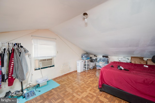 bedroom with cooling unit, vaulted ceiling, and light parquet flooring