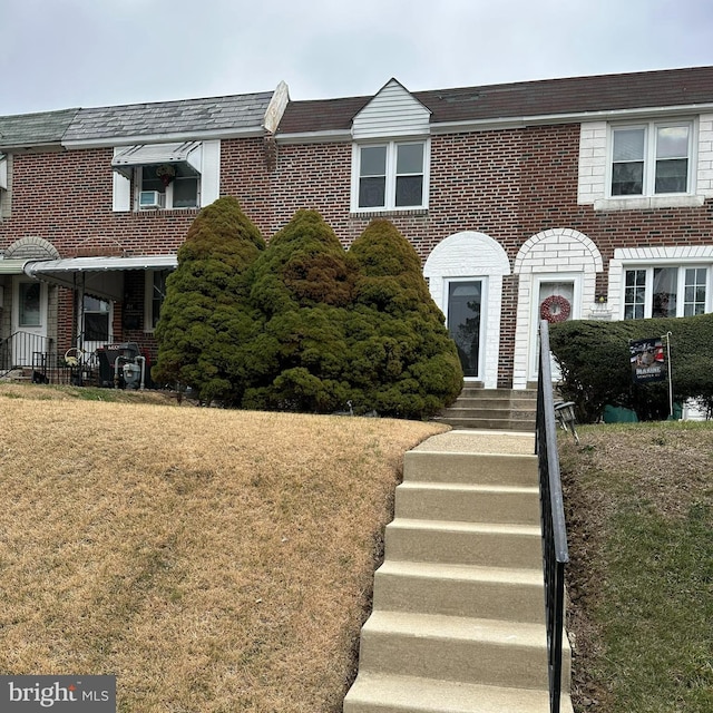 townhome / multi-family property with a front lawn