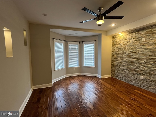 spare room featuring dark hardwood / wood-style flooring and ceiling fan