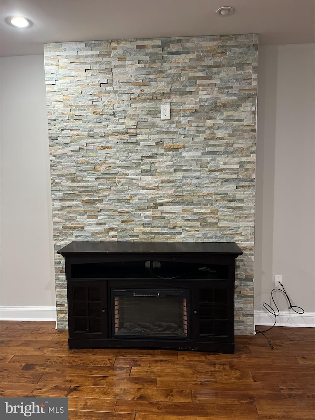 details with wood-type flooring and a tiled fireplace