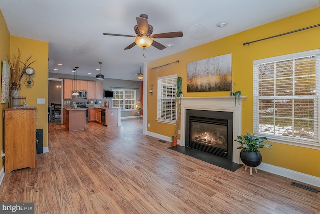 living room with hardwood / wood-style flooring, ceiling fan, and sink