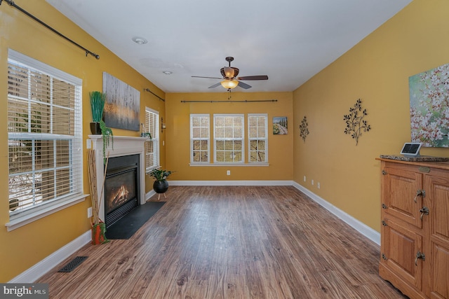 living room with ceiling fan and dark wood-type flooring