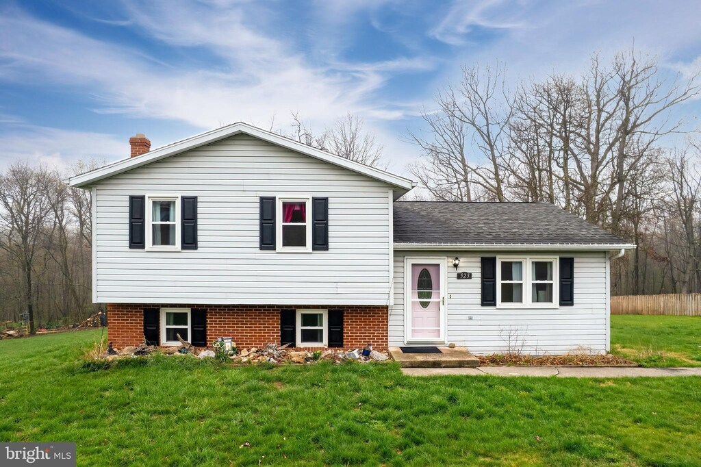 523 W Ridge Loop Rd, Romney, WV 26757 - tri-level home featuring a front yard, roof with shingles, and a chimney