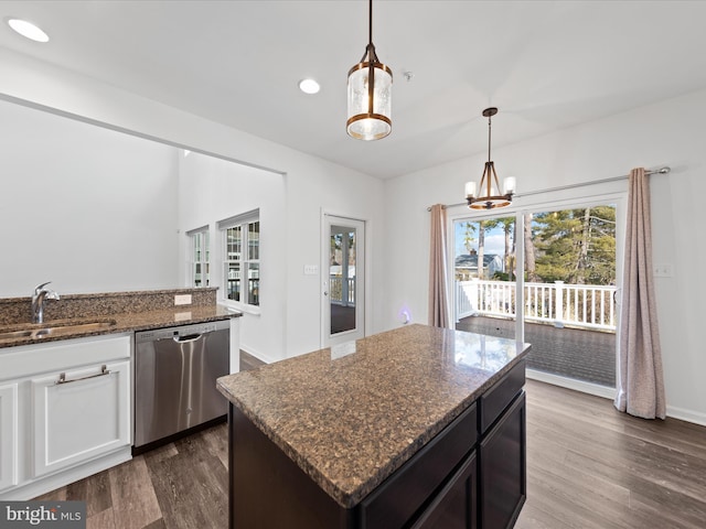 kitchen featuring sink, decorative light fixtures, dark stone counters, and dishwasher