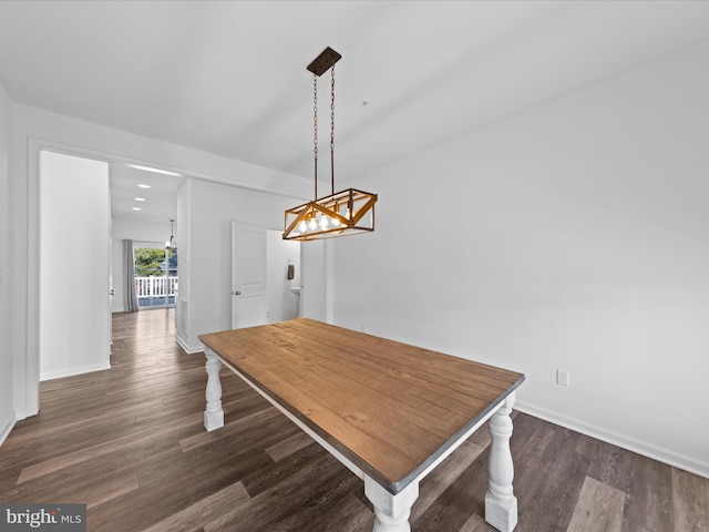 unfurnished dining area with dark hardwood / wood-style flooring and a chandelier