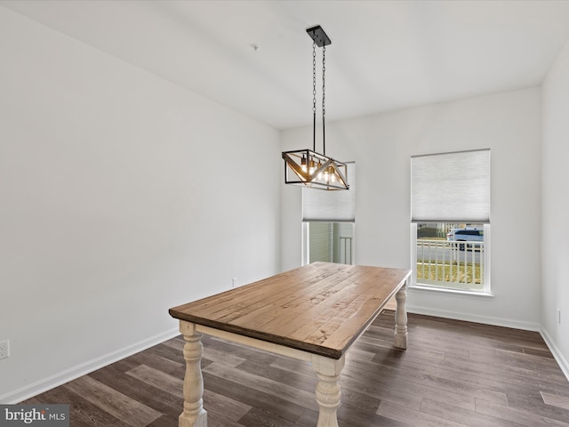 dining space with dark hardwood / wood-style floors and a chandelier