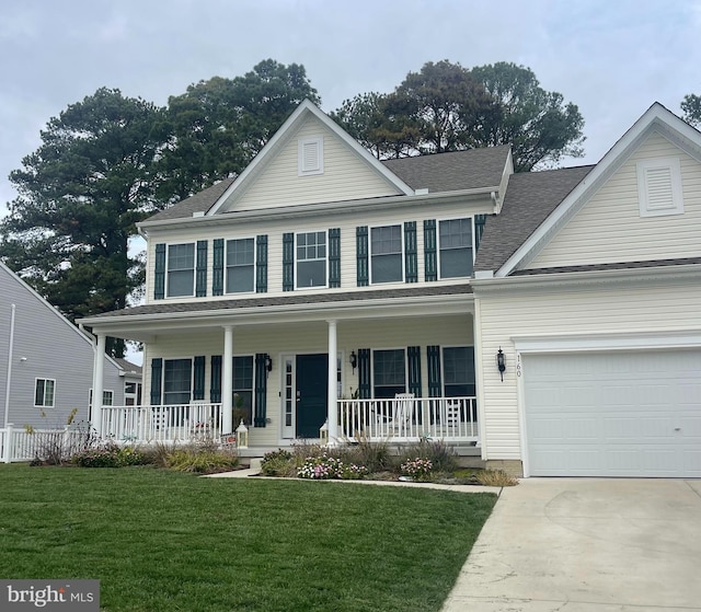 view of front of property with a garage, a front lawn, and covered porch