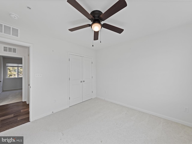 unfurnished bedroom featuring carpet floors, a closet, and ceiling fan