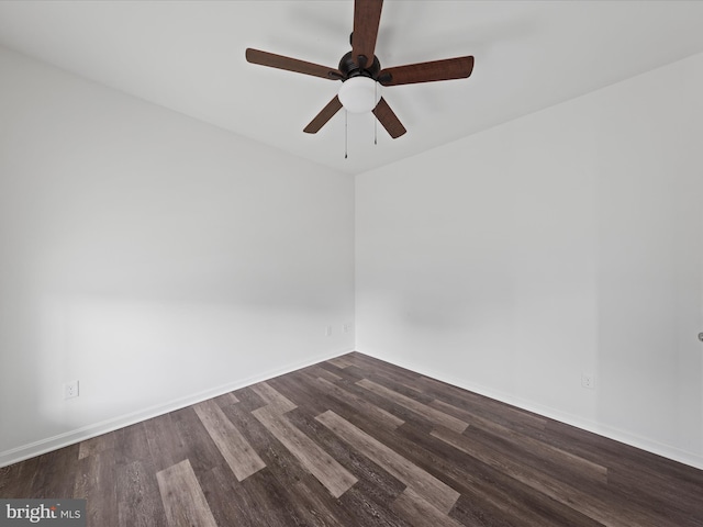 spare room with dark wood-type flooring and ceiling fan