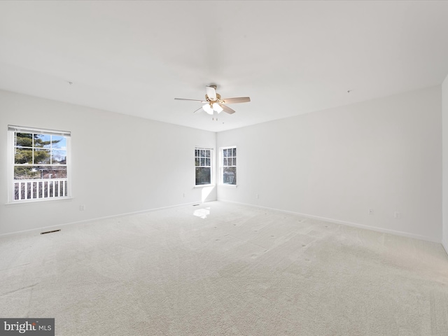 carpeted spare room with ceiling fan