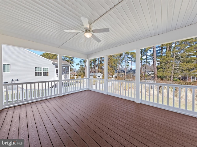 unfurnished sunroom featuring ceiling fan