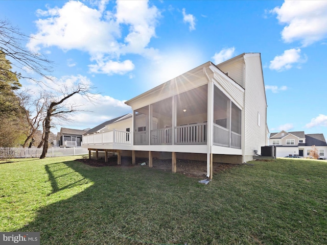 back of property with cooling unit, a yard, and a sunroom