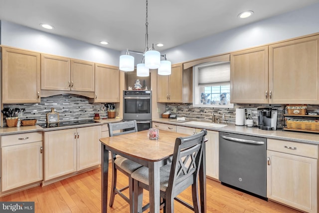 kitchen with tasteful backsplash, sink, hanging light fixtures, appliances with stainless steel finishes, and light brown cabinets