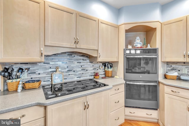 kitchen featuring tasteful backsplash, double oven, light brown cabinetry, and black electric cooktop