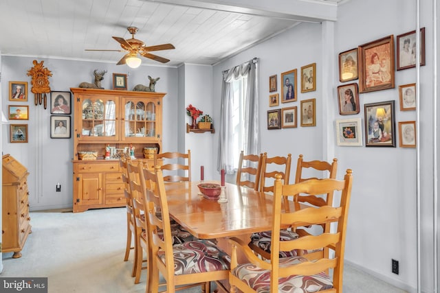 carpeted dining space featuring ceiling fan, crown molding, and wood ceiling