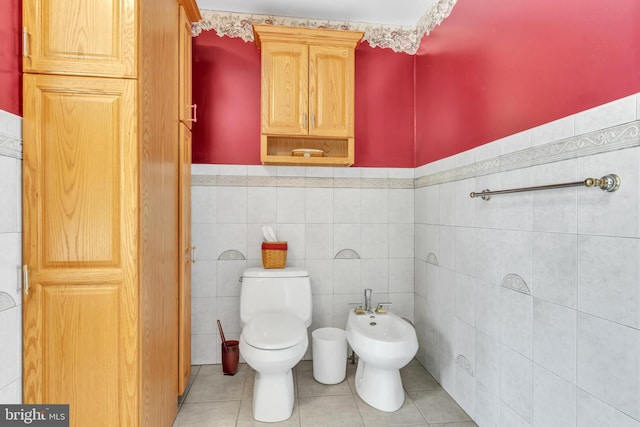 bathroom featuring toilet, tile walls, tile patterned floors, and a bidet