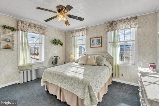 carpeted bedroom featuring ceiling fan, ornamental molding, multiple windows, and radiator heating unit