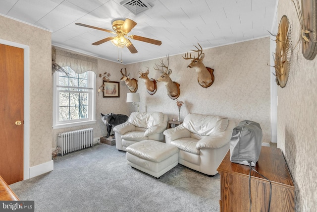 living room featuring ceiling fan, radiator heating unit, ornamental molding, and carpet flooring