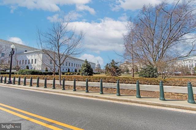 view of street featuring street lights, curbs, and sidewalks