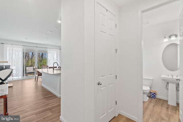 corridor featuring light hardwood / wood-style flooring and sink