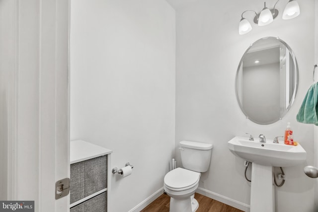 bathroom featuring wood-type flooring and toilet