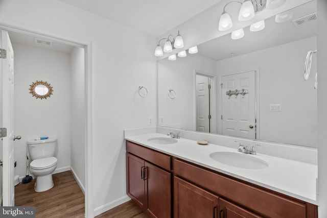 bathroom featuring vanity, toilet, and wood-type flooring