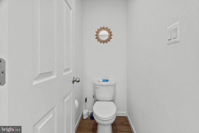 bathroom with hardwood / wood-style flooring and toilet