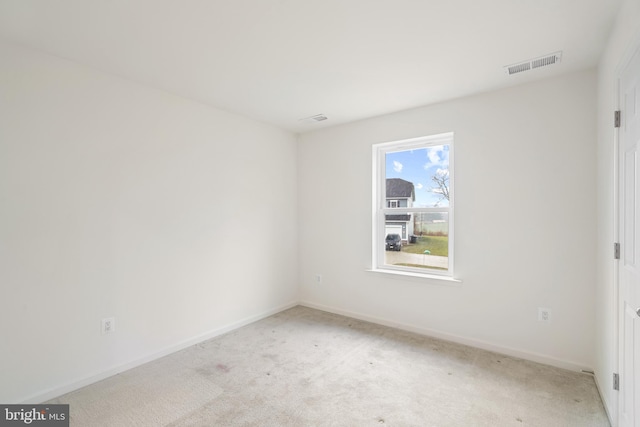 spare room featuring light colored carpet