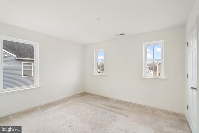 spare room featuring light colored carpet