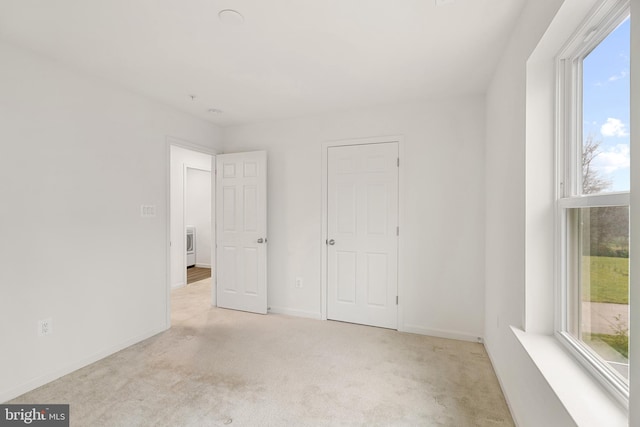 interior space with light colored carpet and multiple windows