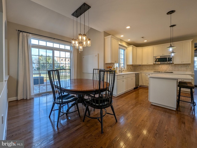 dining room featuring an inviting chandelier, dark hardwood / wood-style flooring, and sink