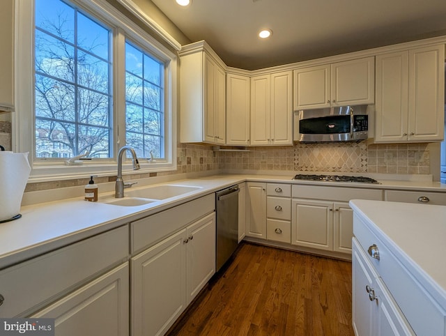 kitchen featuring sink, stainless steel appliances, dark hardwood / wood-style flooring, and white cabinetry