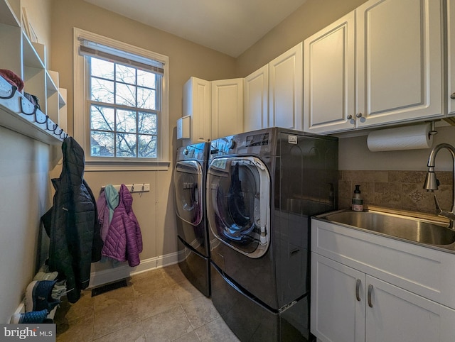 laundry room with cabinets, separate washer and dryer, light tile patterned floors, and sink